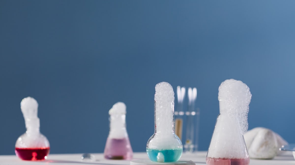 Vibrant chemical reactions in flasks with bubbles in a lab setting.